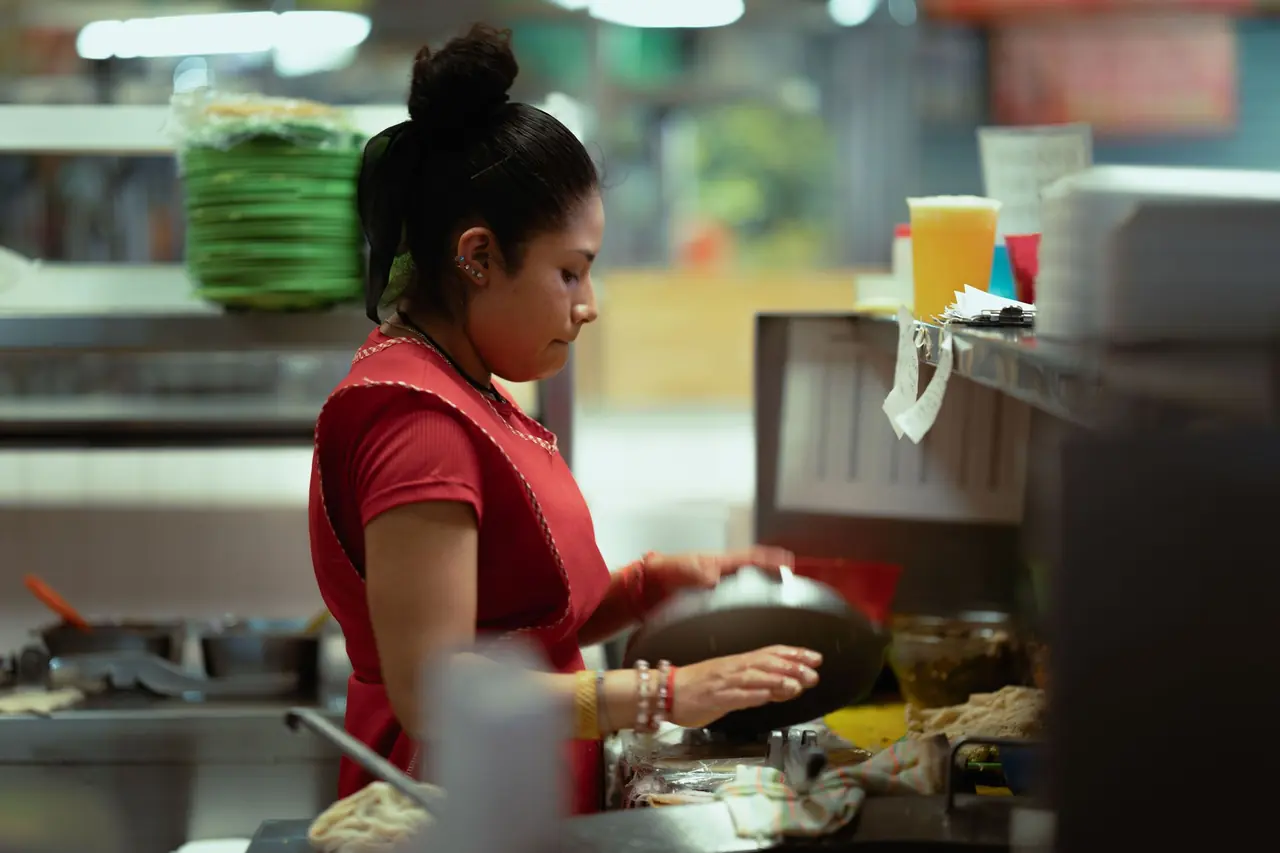 A cook preparing food in a busy restaurant kitchen
